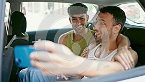 Two men couple having video call sitting on taxi at street