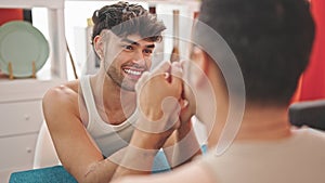 Two men couple sitting on table with hands together at dinning room