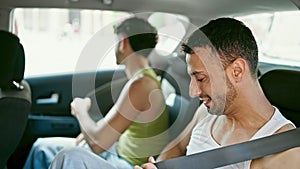 Two men couple wearing belt sitting on taxi at street