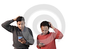 Two men with different ethnicities looking at their phone and confused and scratching heads in white background with