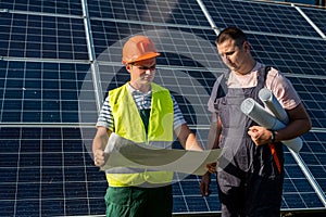 Two men discussing installation plan of new solar station. Green energy concept