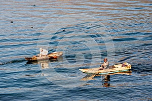 Two men in dugout canoes on Lake Atitlan, Guatemala