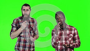 Two men eating french fries on green screen