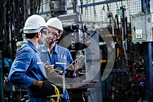 Two men engineer talking in modern factory.