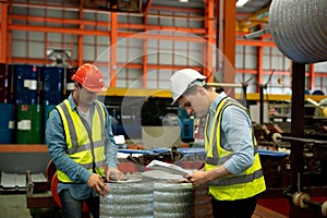 Two men engineer talking in modern factory. Production line machine and setting it for work