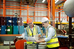 Two men engineer talking in modern factory. Production line machine and setting it for work