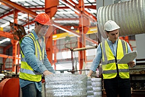 Two men engineer talking in modern factory. Production line machine and setting it for work