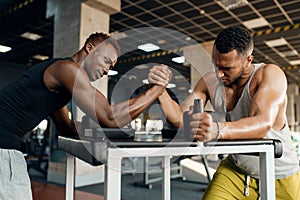 Two men fighting, arm wrestling training in gym