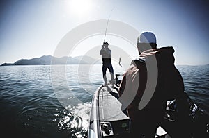 Two men fishing on a bass boat on the lake