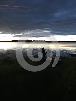 Two men fishing on a lake at twlight