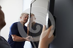 Two Men Fitting Flat Screen Television To Wall photo