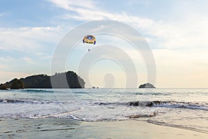 Two men floating from a parasail wing in the sky, Manuel Antonio, Puntarenas province photo