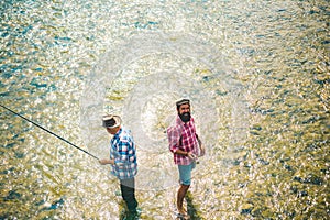 Two men friends fisherman fishing on river. Old father and son with rod fishing at riverside. Recreational activity.