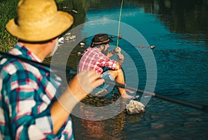 Two men friends fisherman fishing on river. Old father and son with rod fishing at riverside. Recreational activity.