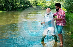 Two men friends fisherman fishing on river. Old father and son with rod fishing at riverside. Recreational activity.