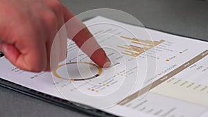 Two men going over monthly budget report, detail on paper and their hands, one holding pen