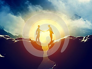 Two men handshake over mountains precipice. Business photo