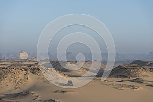 Two men having a breakfast tea next to their jeep 4x4 Landcruiser in the Egyptian desert with the mountains of the Western desert