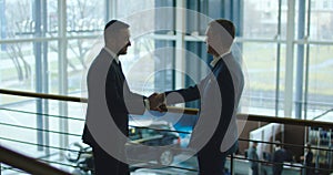 Two men having conversation in car showroom