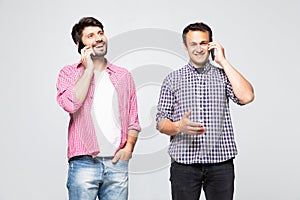 Two men having conversation by phones mobile on white background