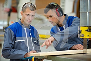 Two men having conversation in wood workshop