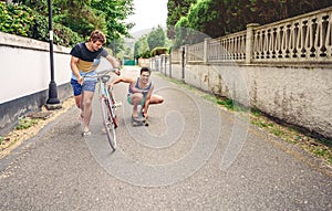 Two men having fun riding bike and skateboard