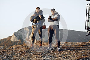 Two men hikers standing near off-road car getting ready to start their journey