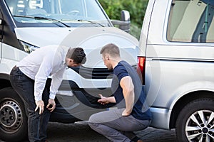 Two Men Inspecting The Car Damaged After Accident