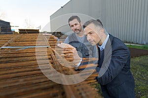 two men inspecting reinforcement bars