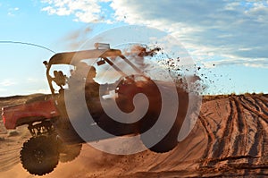 Two Men Jumping a Four Wheeler Over a Sand Dune