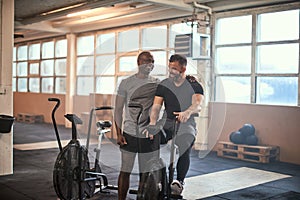 Two men laughing after a stationary bike workout