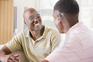 Two men in living room talking and smiling