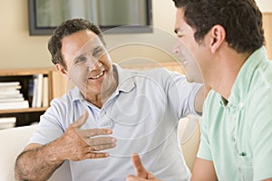 Two men in living room talking and smiling