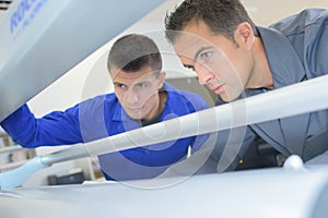 Two men looking into printing machine