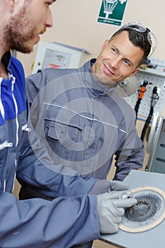 two men on machine processes metal detail