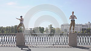Two men in marine uniform show weird movements, staying on postament at seafront. Surrealism