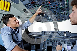 Two men in modern flight simulator for pilot training