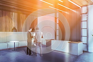 Two men near white and gray reception desk