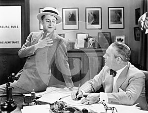 Two men in an office talking with each other