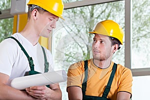 Two men in overalls and hardhat during work