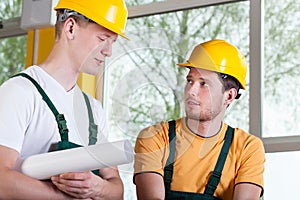 Two men in overalls and hardhat during work photo