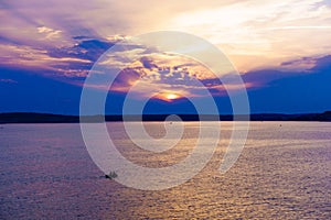 Two men paddling in an inflatable kayak in colorful sunset