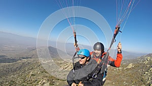 Two men paragliding over the hill