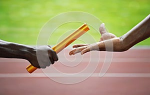 Two men passing golden baton in stadium. Conceptual image shot photo