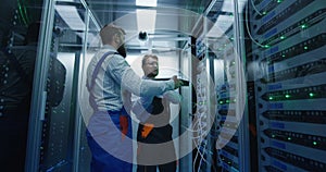 Two men performing maintenance in a data center