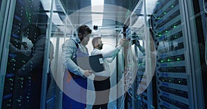 Two men performing maintenance in a data center