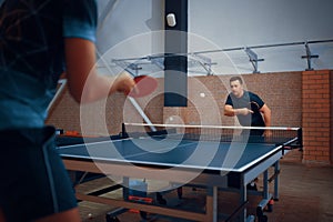 Two men play table tennis, ping pong players