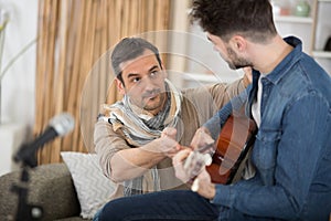 two men playing acoustic guitar