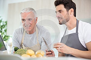 two men preparing vegetables in home