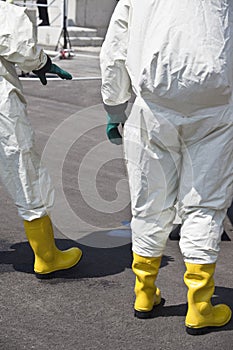 Two men in protective gear disinfecting contaminated areas